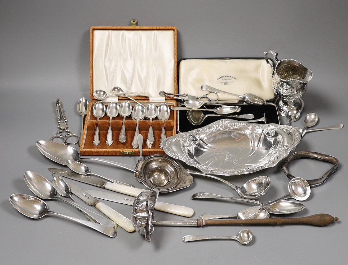 An Edwardian repousse silver oval dish, Birmingham, 1904, 22.8cm, a small quantity of assorted silver flatware including 18th and 19th century pairs of sugar nips, an 18th century silver toddy ladle, white metal cream ju